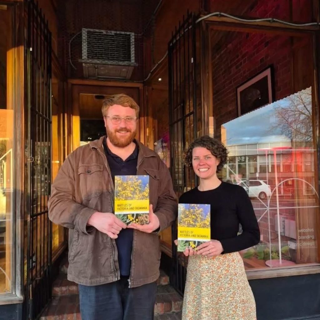 Authors holding books outside a shop in Australia.