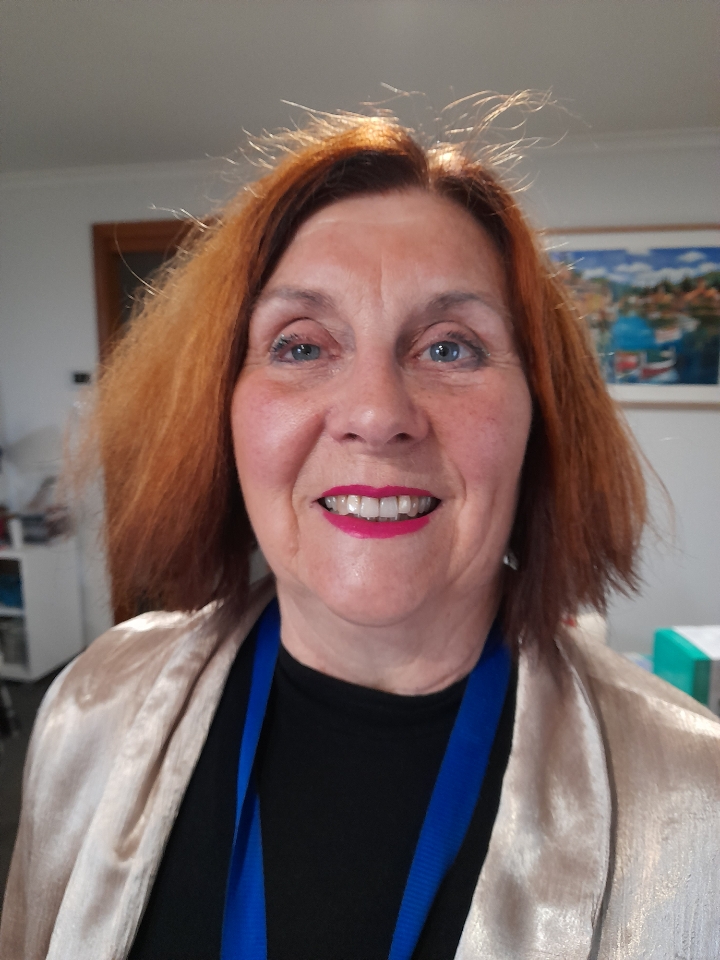 Smiling woman with short hair indoors.