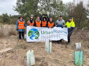Volunteers holding Urban Ripple banner in bushland.