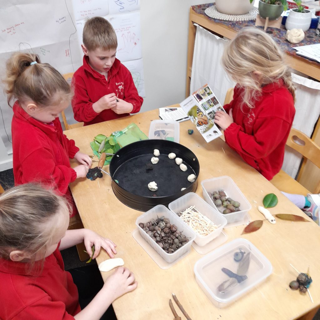Children doing nature craft and studying guide.